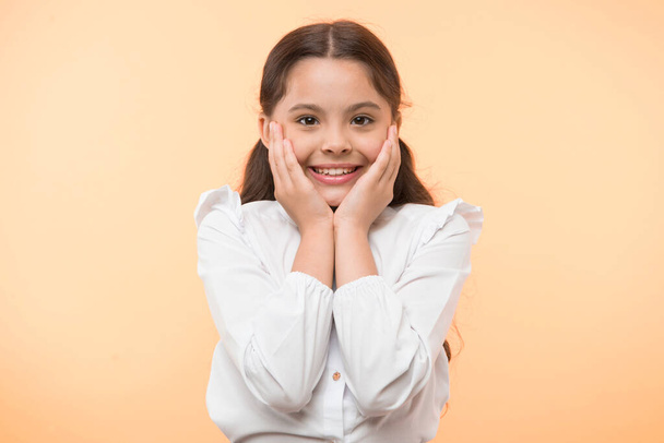 Full of excitement. Girl happy smiling face touches her cheeks yellow background. Schoolgirl can not wait to back to school. Waiting september. Pupil excited about back to school - Foto, imagen