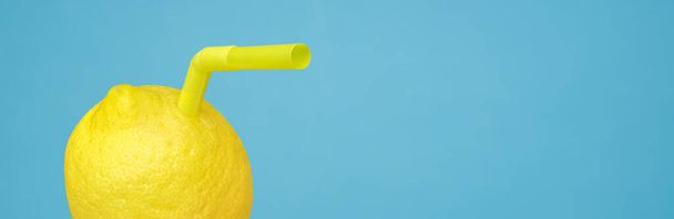 青のバナーに本物の果物で作られたわらや天然の新鮮なレモネードとガラスのドリンクとしてジューシーなレモンを熟す。レモンフルーツのビタミンC最小限のコンセプトまたは自家製レモネード絞りさわやかな飲み物 - 写真・画像
