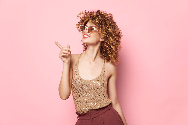 Hermosa mujer pelo rizado Sonrisa gafas de sol moda rosa fondo Copiar Espacio  - Foto, imagen