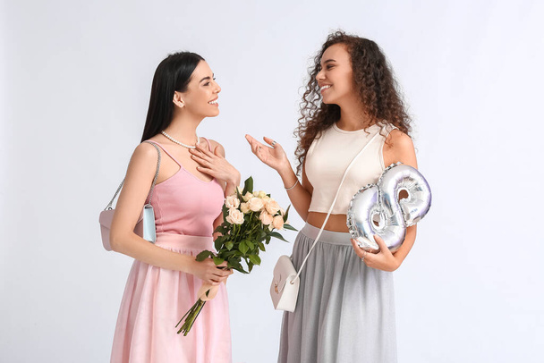 Schöne Frauen mit Luftballon und Blumen auf weißem Hintergrund. Feier zum Internationalen Frauentag - Foto, Bild