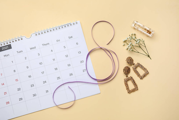 Calendar with female accessories on color background. International Women's Day celebration - Photo, Image