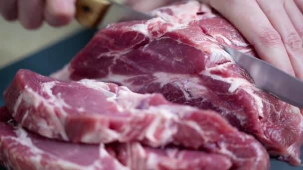 Kuchař krájí čerstvé maso na kousky nožem. nakrájené maso na steak. - Záběry, video