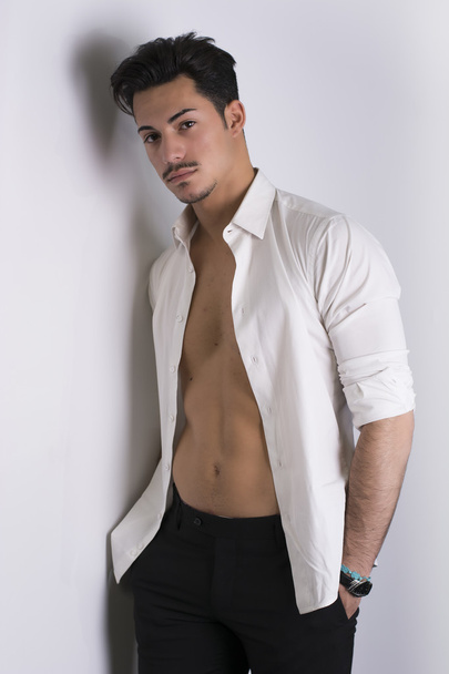 Elegant attractive young man with white shirt open on naked torso - Foto, Bild