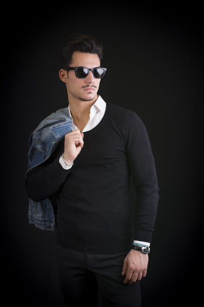 Attractive, trendy young man with black sweater and sunglasses - Foto, Imagen