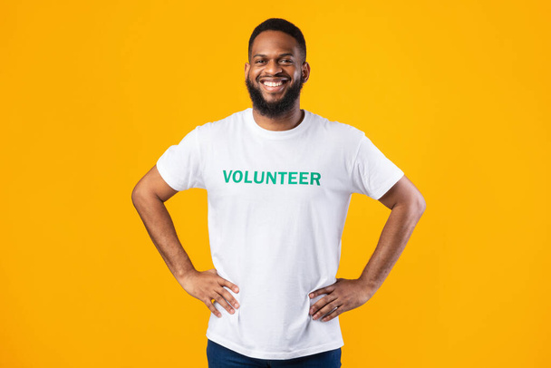Веселый африканский доброволец, позирующий на жёлтом фоне - Фото, изображение