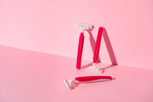 Pink disposable razors on pink background, copy space - Fotó, kép