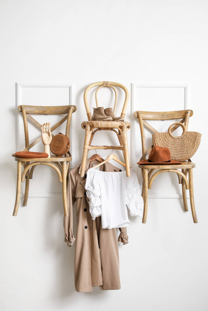 Chaises avec vêtements et accessoires suspendus au mur de lumière dans la chambre - Photo, image