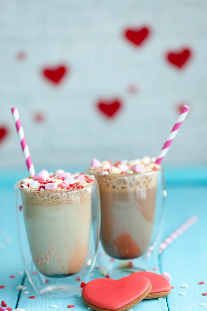 Two glasses of hot coffee or cappuccino with marshmallows and heart-shaped cookies on a light blue wood background. Holiday Valentine's Day. - Foto, immagini