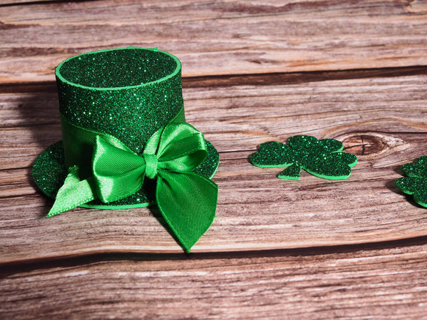 Green hat with golden coins and shamrock on wooden table, st patricks day concept - Photo, Image
