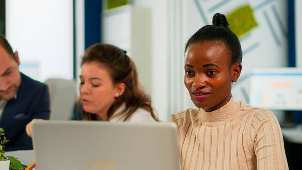 Porträt einer entzückten afrikanischen Geschäftsfrau, die gute Nachrichten auf dem Laptop liest - Foto, Bild