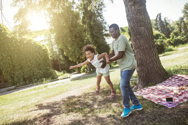 African american dad and his daughter having good time together in the park and feeling playful - Φωτογραφία, εικόνα