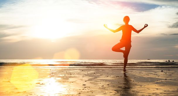 mujer joven practicando yoga en la playa - Foto, Imagen