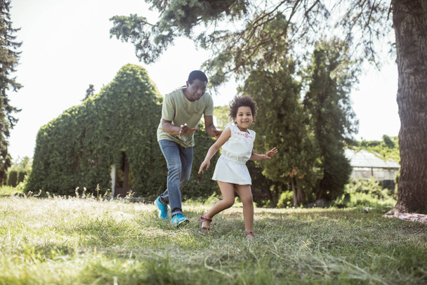 Dad and a cute girl running in the park and feeling happy - 写真・画像