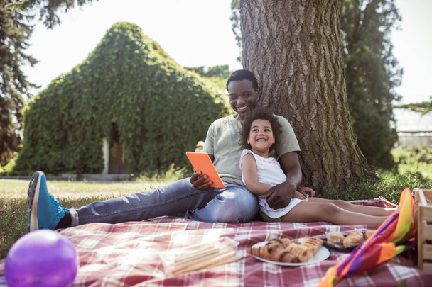 African american man and his cute kid having picnic in the park - Fotografie, Obrázek