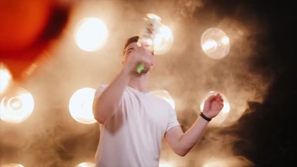 Professionale barista uomo bottiglia giocoleria sul fumo e sfondo luce - Filmati, video