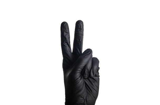 Vereinzelte Männerhände in einem schwarzen Gummihandschuh - Foto, Bild