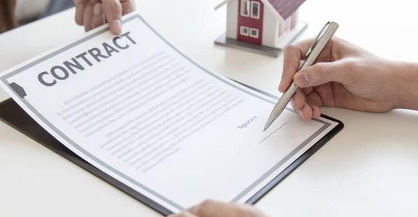 不動産代理店や販売管理者は、保険と住宅購入契約を締結する顧客に契約条件を提案しています,購入契約の概念に署名する契約. - 写真・画像