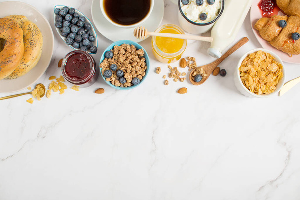 Mesa de pequeno-almoço com aveia, croissants, frutas frescas, muesli e bagas. vista superior, deitado plano. Café da manhã saudável. - Foto, Imagem