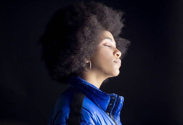 bonita mujer afro sobre fondo negro con los ojos cerrados - Foto, Imagen