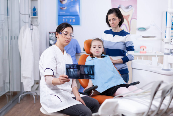 Tandheelkundige specialist praten over holte procedure - Foto, afbeelding