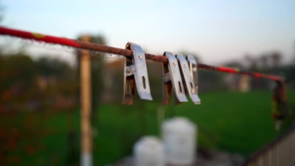 Swinging Steel cloth clip or clothe pins on the plastic rope to dry clothes. Chromium clips to stable clothes and to safe from flying in air. - Footage, Video