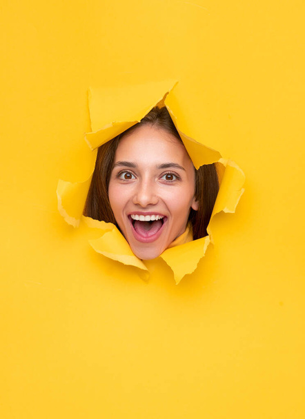 Excited woman in torn paper hole - Photo, Image