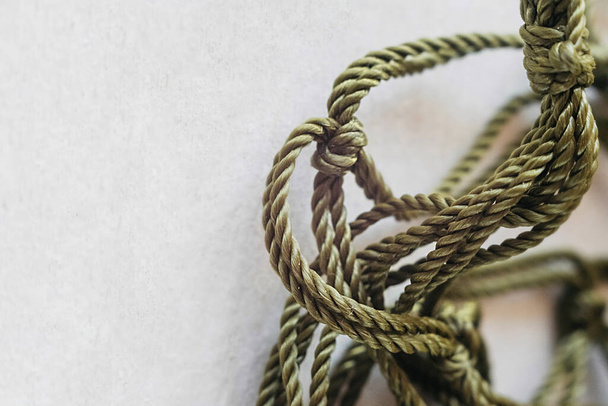 緑の糸から紐袋を織る工程です。結び目を持つ高密度のパラコードを閉じて - 写真・画像
