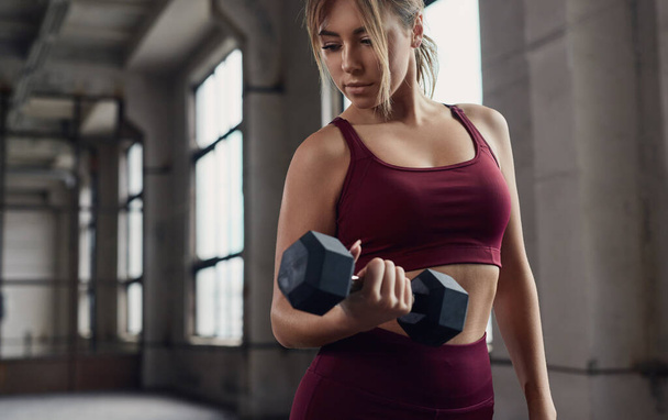 Fit woman training with dumbbells in gym - Фото, зображення