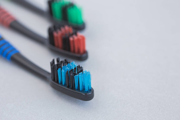 Set of multicolored toothbrushes on gray background - Фото, изображение