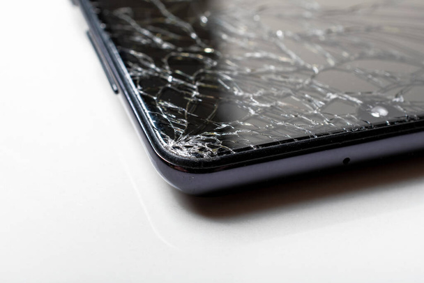 Macro φωτογραφία ενός κινητού τηλεφώνου με σπασμένη οθόνη. Επιλεκτική εστίαση. - Φωτογραφία, εικόνα