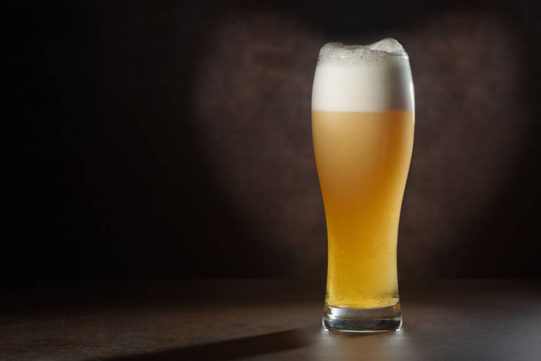 Piwo.Pint of Beer zbliżyć izolowane na abstrakcyjnym tle. Zimne piwo rzemieślnicze w szklance - Zdjęcie, obraz