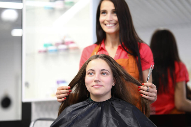 Master fryzjer posiada włosy klienta w salonie piękności - Zdjęcie, obraz