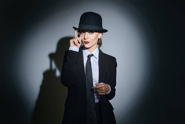 attractive young woman in a man's suit and a fedora. retro style photo shoot - Foto, afbeelding