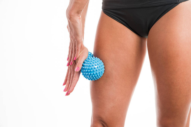 Egy sportoló nő masszírozza az izmait a labdával. - Fotó, kép