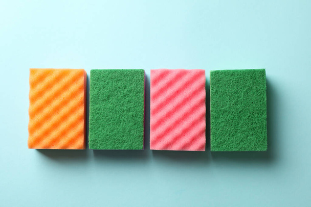 Color sponges for cleaning on blue background - 写真・画像