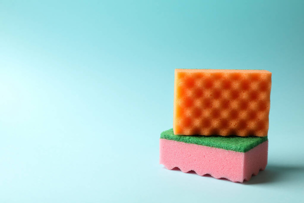 Color sponges for cleaning on blue background - Foto, afbeelding