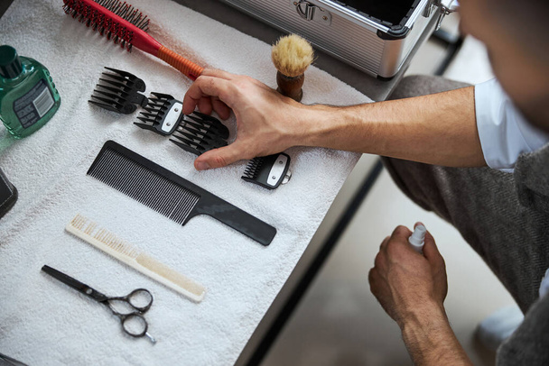 Escritorio de peluquería con máquina moderna especial y cepillo en la peluquería - Foto, imagen