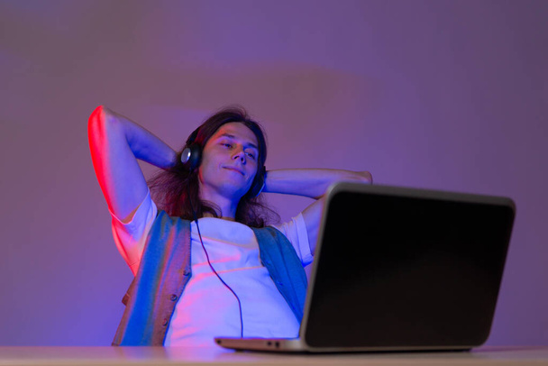 Gamer or programmer at a laptop, portrait in neon light. Take a break from work, - Foto, imagen