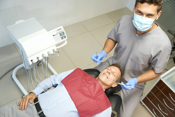 Ambitny młody dentysta pozował ze swoim pacjentem - Zdjęcie, obraz
