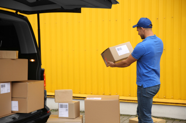 Кур'єр з посилками поблизу доставки фургон на відкритому повітрі
 - Фото, зображення