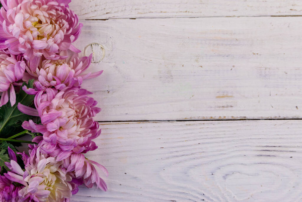 Krásné chryzantémy na bílém dřevěném pozadí. Horní pohled, kopírovací prostor - Fotografie, Obrázek