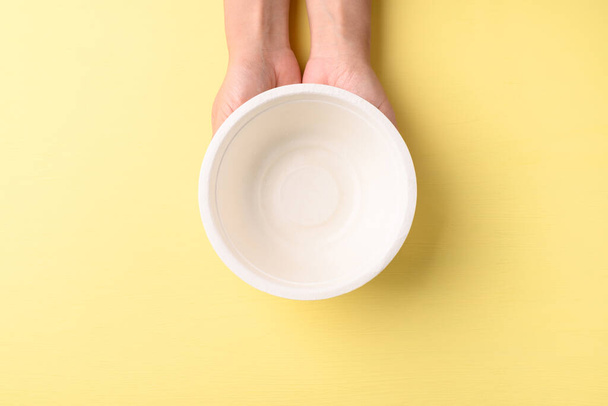 Hand holding bowl(Biodegradable, Compostable, Disposable or Eco friendly bowl) on yellow background, Sustainable concept - Fotoğraf, Görsel