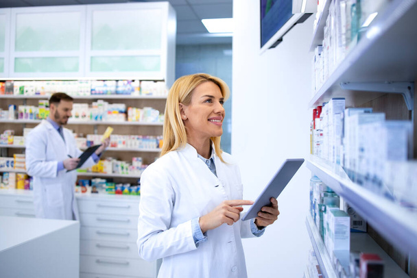 Жінка-нарколог перевіряє ліки на полиці в аптеці
. - Фото, зображення