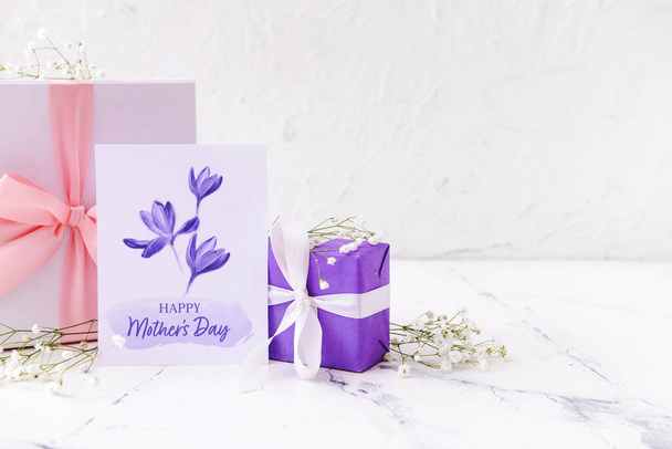 Regalos y tarjeta de felicitación para el Día de la Madre sobre fondo claro - Foto, Imagen