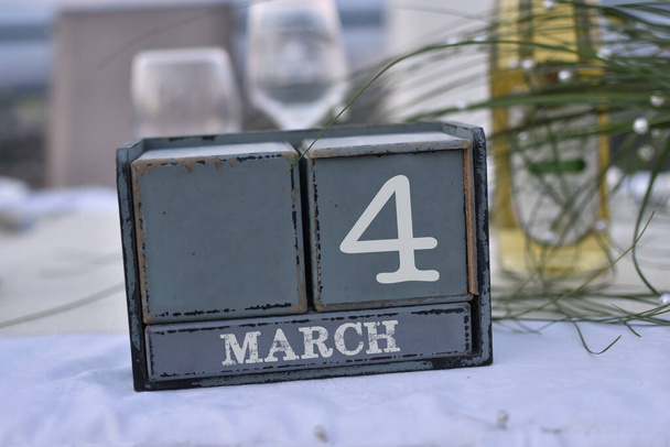 Bloques de madera en caja con fecha, día y mes 4 de marzo. Calendario de bloques de madera - Foto, imagen