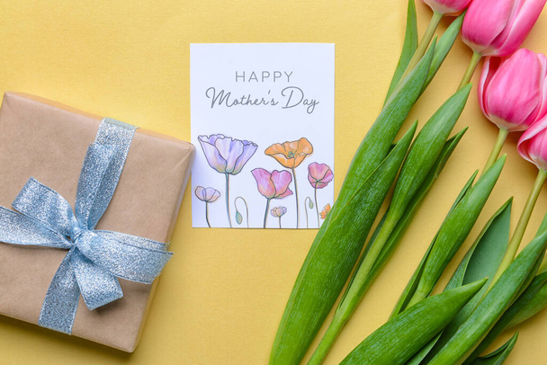 Красивые цветы, подарки и поздравительные открытки на День матери на цветном фоне - Фото, изображение