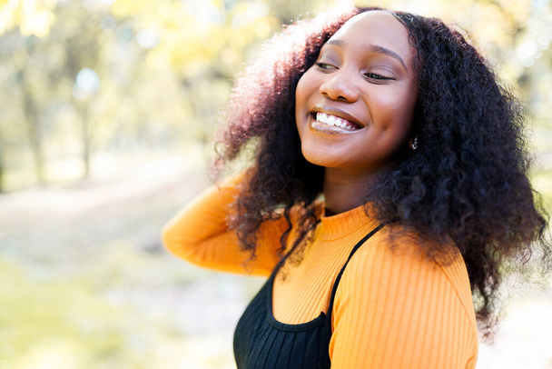 Nette schwarze Frau lächelt in einem Park - Foto, Bild