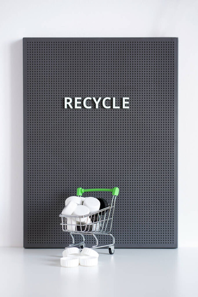Lids in small cart on a grey board with recycle word - Photo, Image