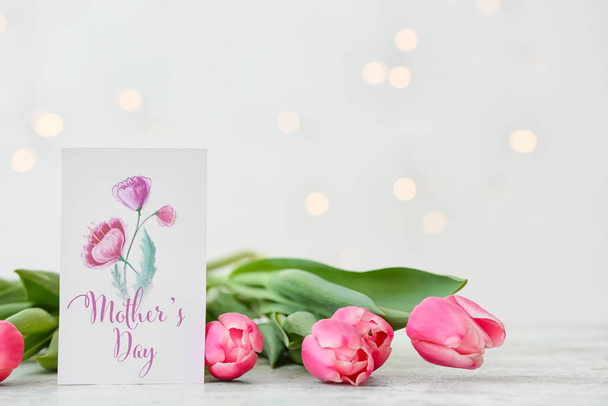 Прекрасні квіти і листівка для Дня матері на світлому фоні - Фото, зображення