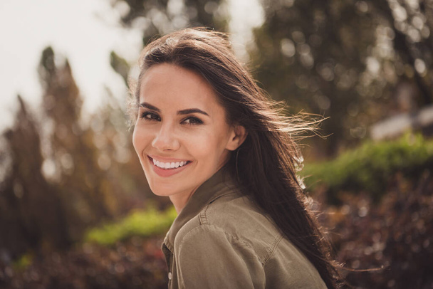 Foto de coquete paquera linda jovem senhora olhar câmera brilhante sorriso desgaste camisa marrom parque rua ao ar livre - Foto, Imagem